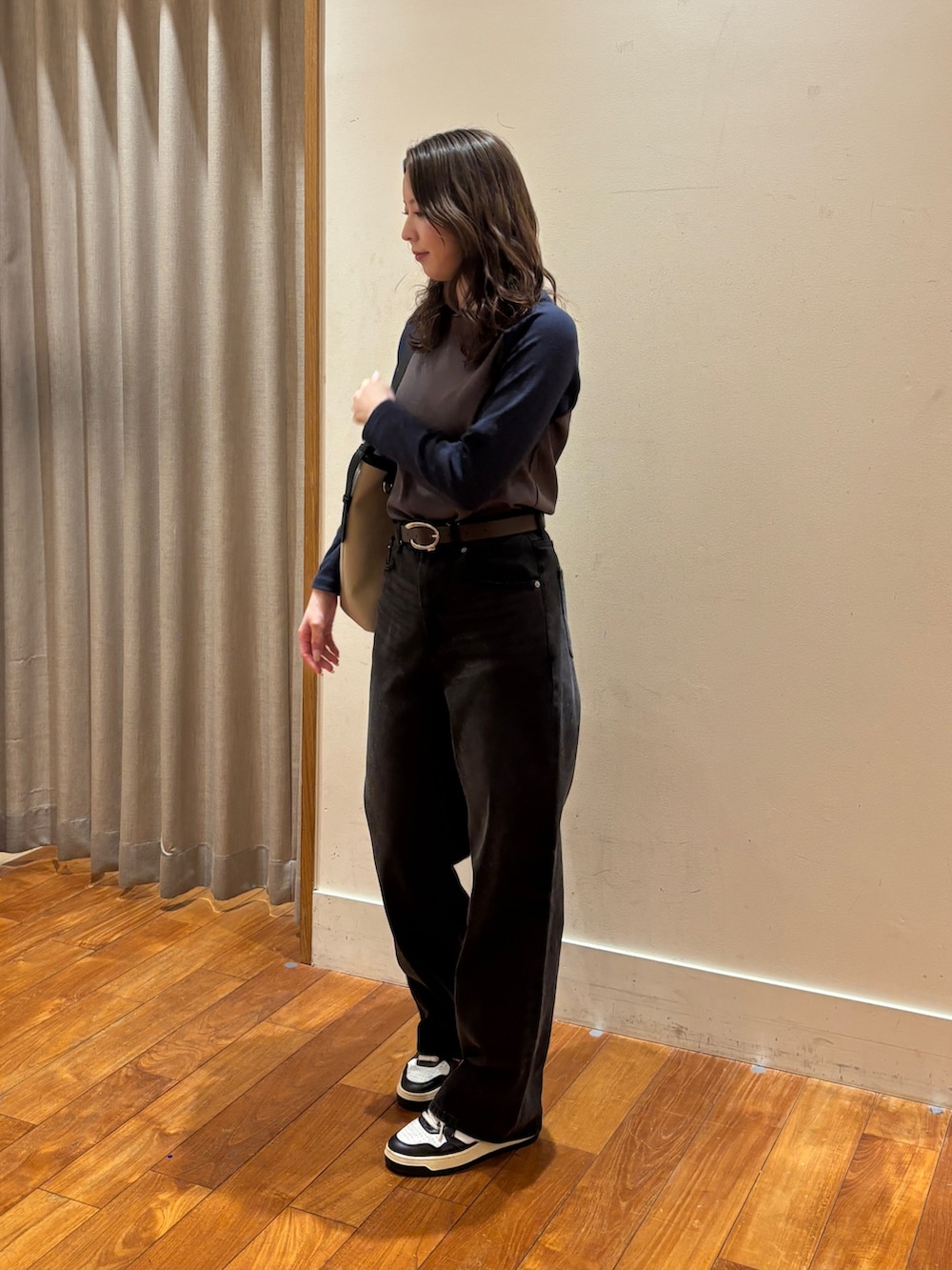 ブラック系のデニムパンツ、ブラック系のショルダーバッグ、グレー系のTシャツ/カットソーを着用したレディースの春コーディネートの2枚目の写真