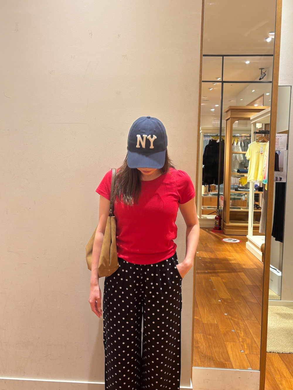 レッド系のTシャツ/カットソー、イエロー系のショルダーバッグ、ブラック系のその他パンツを着用したレディースの夏コーディネートの4枚目の写真