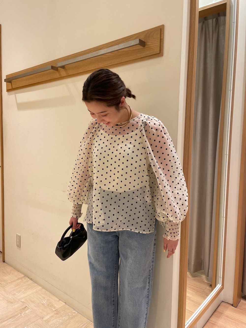 ホワイト系のシャツ/ブラウス、オレンジ系のトートバッグ、ブルー系のデニムパンツを着用したレディースの春コーディネートの3枚目の写真