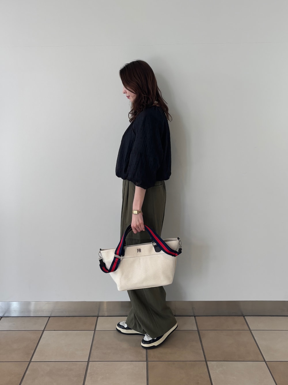 ホワイト系のショルダーバッグ、グリーン系のその他パンツ、ブラック系のシャツ/ブラウスを着用したレディースの春コーディネートの2枚目の写真