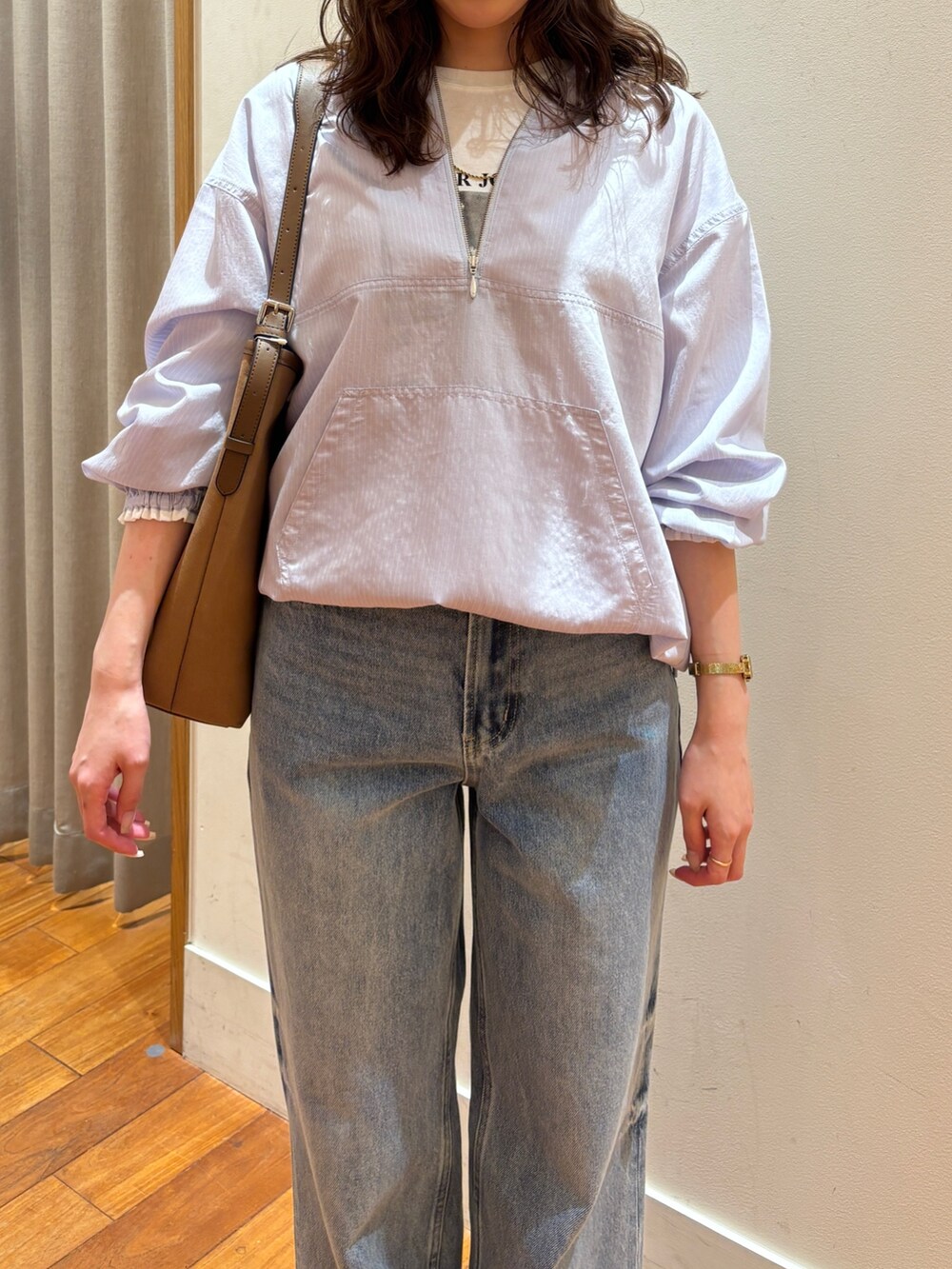 ブルー系のデニムパンツ、ブラウン系のショルダーバッグ、ホワイト系のTシャツ/カットソーを着用したレディースの春コーディネートの4枚目の写真