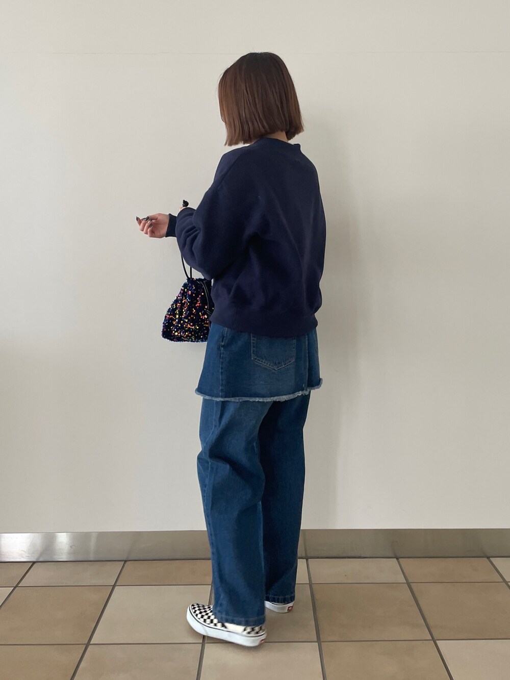 ブルー系のスウェット、ブルー系のデニムパンツ、ブルー系のショルダーバッグを着用したレディースの冬コーディネートの2枚目の写真