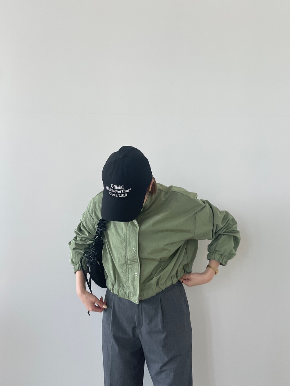 グリーン系のブルゾン、ブラック系のショルダーバッグを着用したレディースの春コーディネートの2枚目の写真