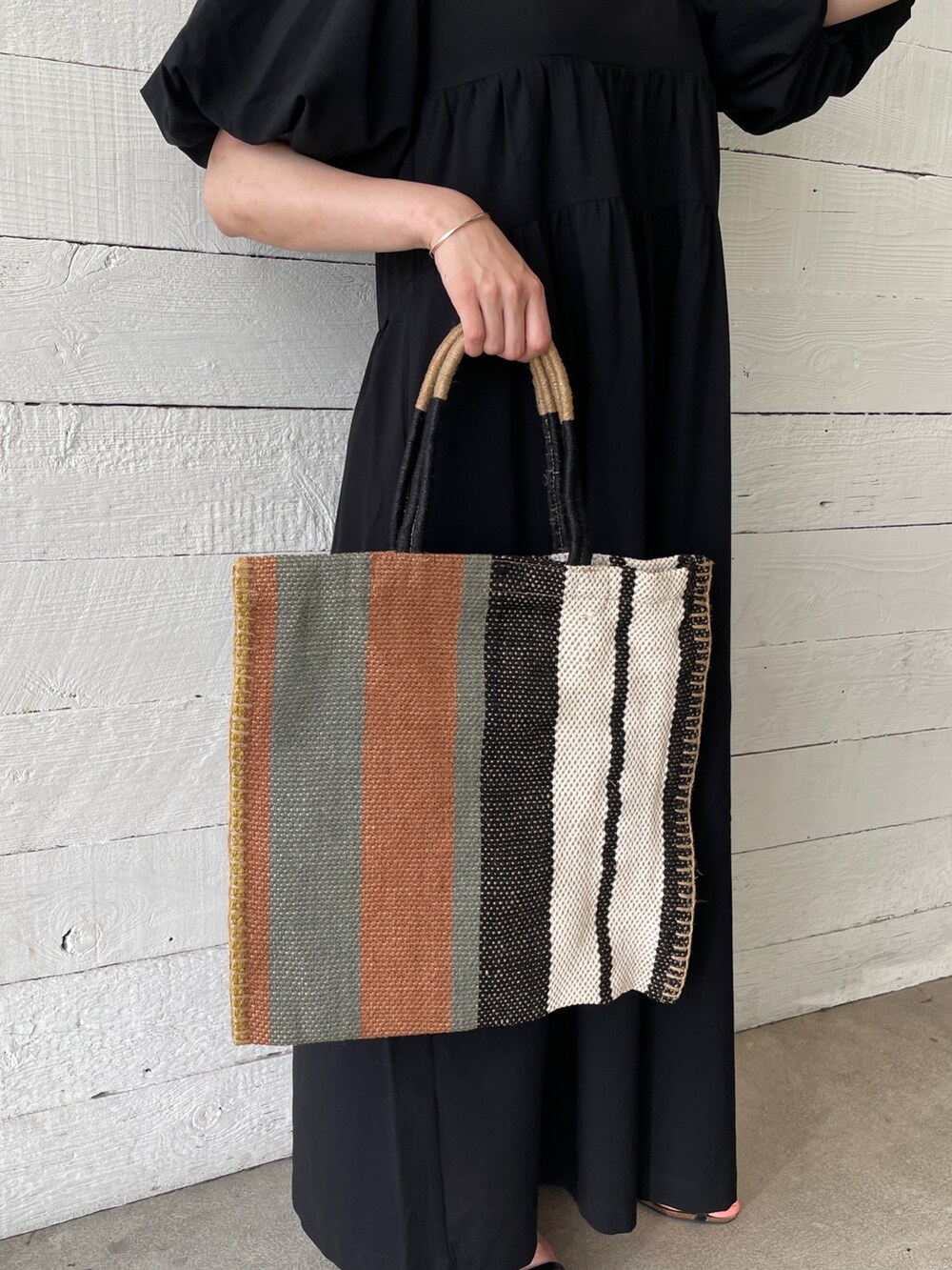 ホワイト系のTシャツ/カットソー、ブラック系のサンダル、グリーン系のトートバッグを着用したレディースの春コーディネートの3枚目の写真