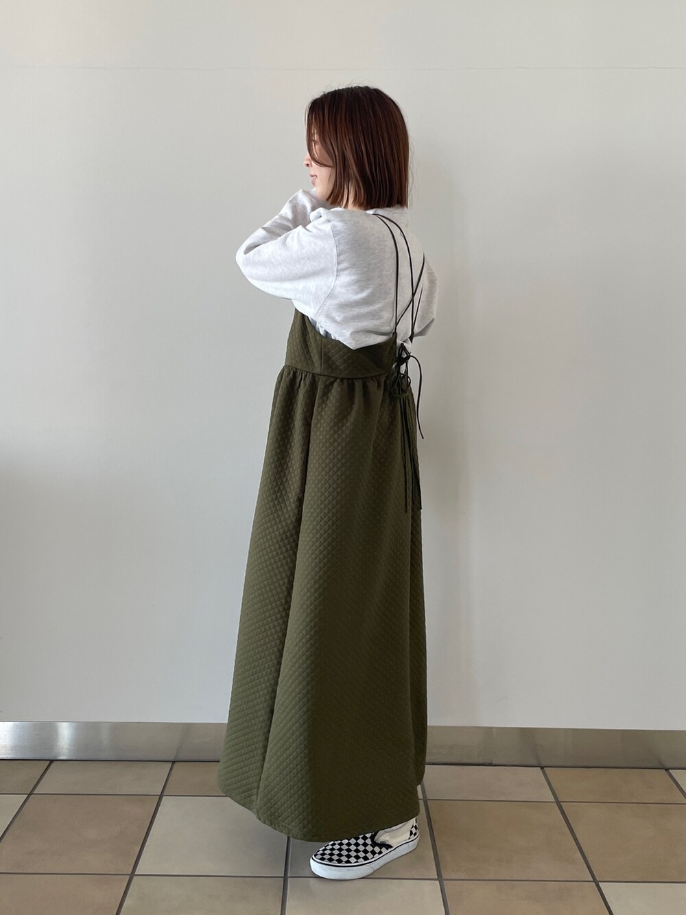 グリーン系のワンピース、グレー系のスウェットを着用したレディースの冬コーディネートの2枚目の写真