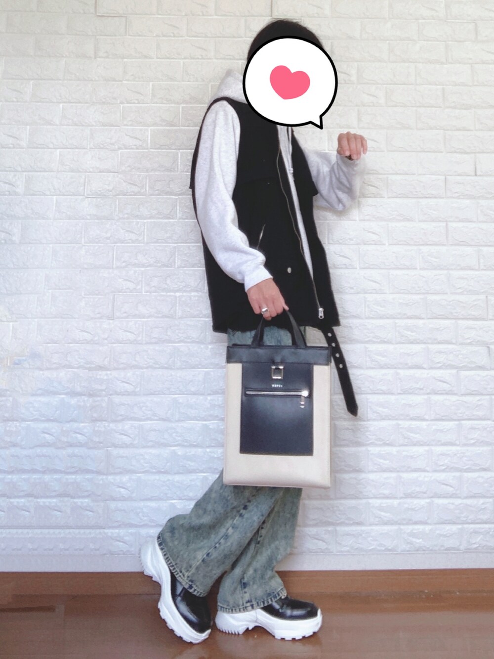 グレー系のパーカー、ブラック系のベスト、ベージュ系のトートバッグを着用したメンズの夏コーディネートの2枚目の写真