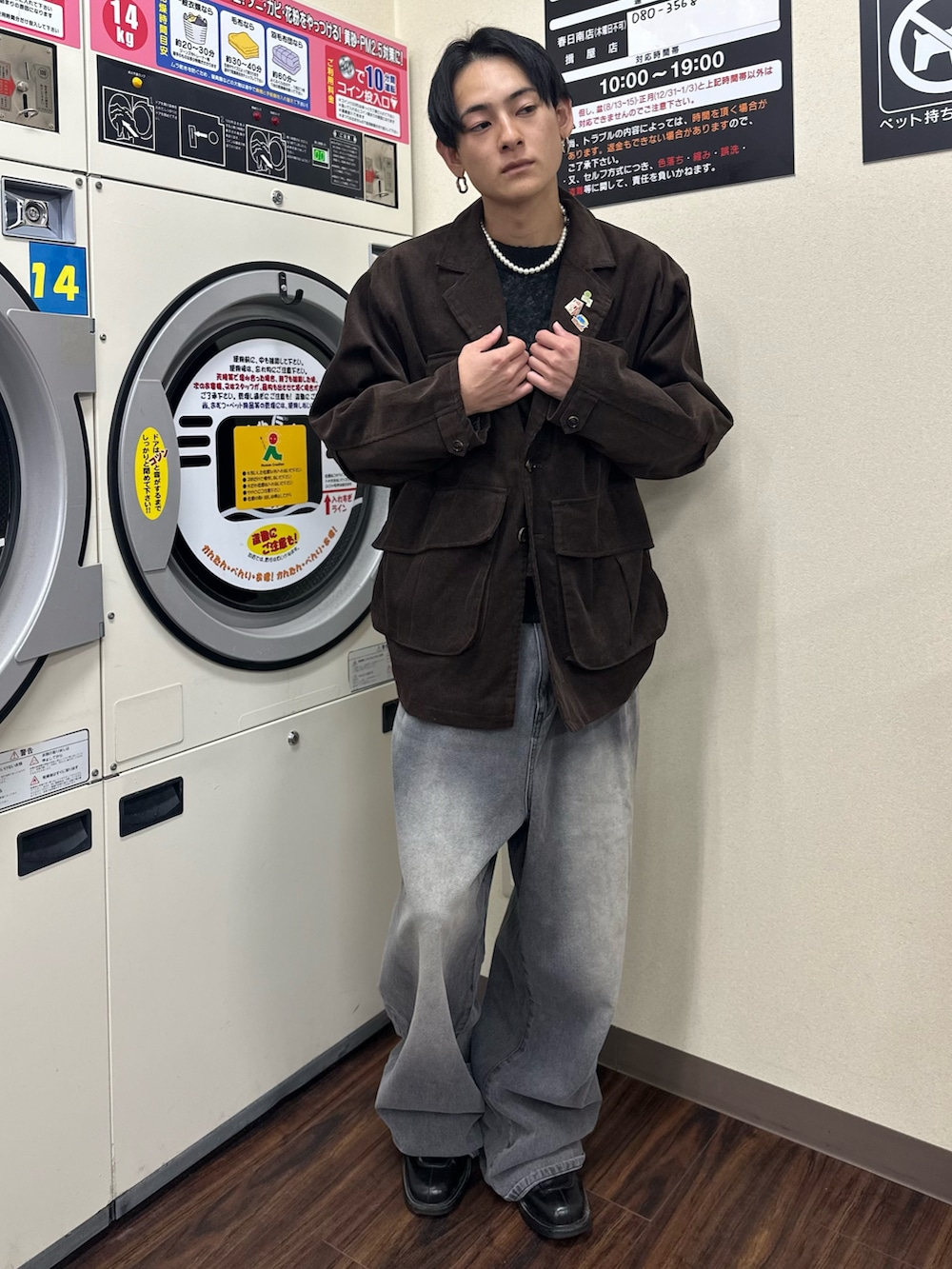 ブラウン系のテーラードジャケット、ブラック系のニット/セーター、グレー系のデニムパンツを着用したメンズの秋コーディネートの3枚目の写真