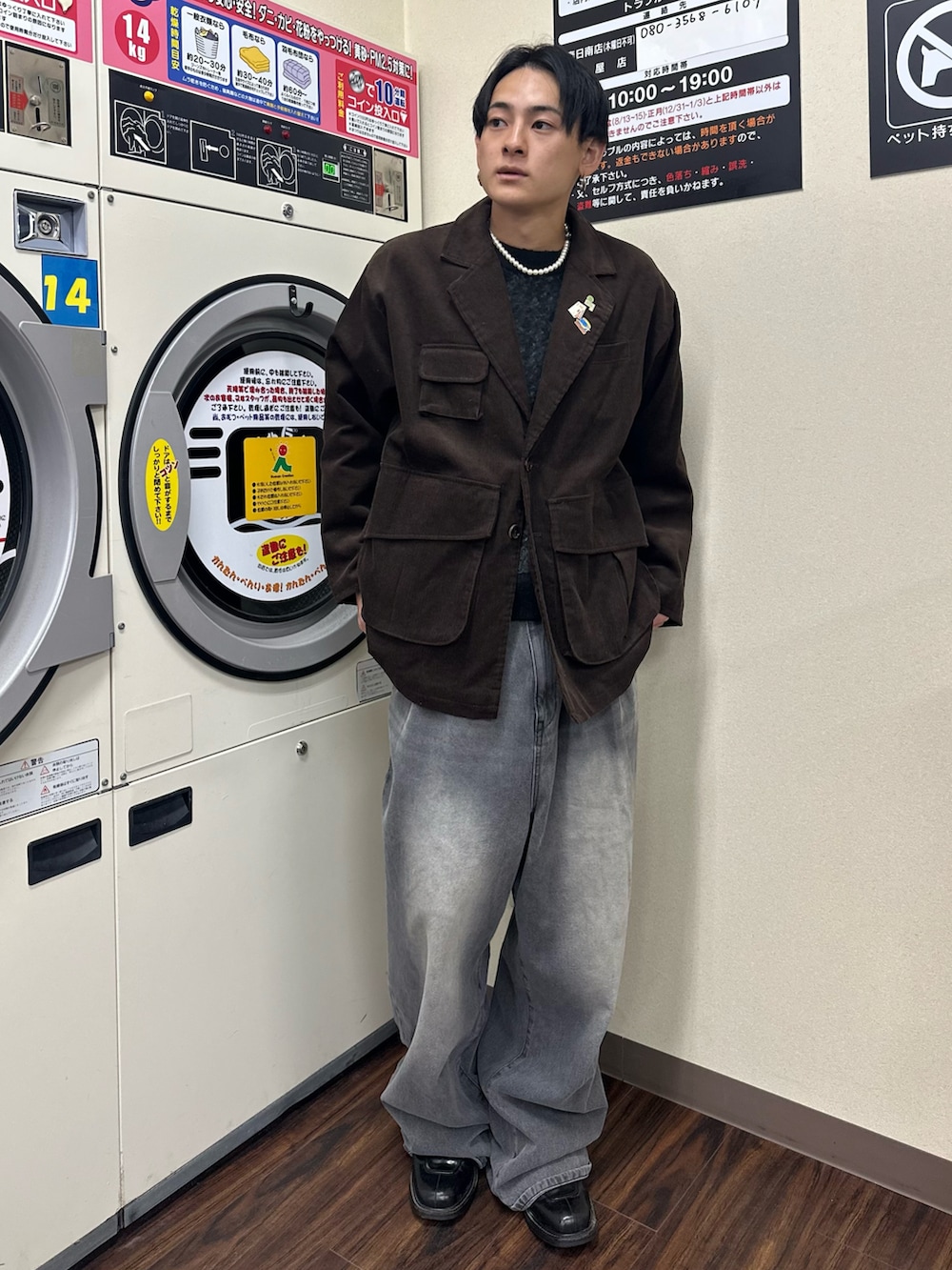 ブラウン系のテーラードジャケット、ブラック系のニット/セーター、グレー系のデニムパンツを着用したメンズの秋コーディネートの2枚目の写真