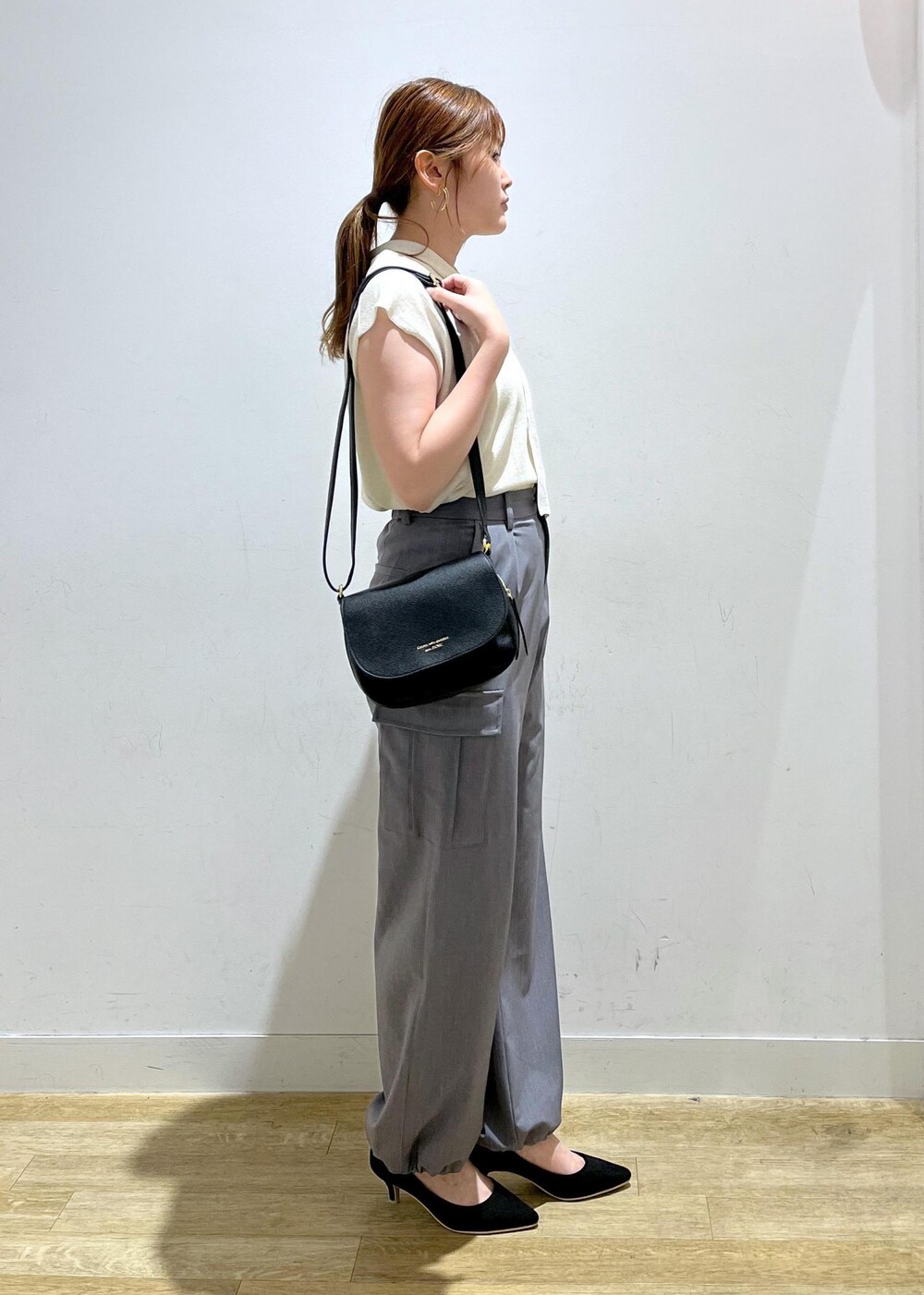 ホワイト系のニット/セーター、グレー系のカーゴパンツ、ブラック系のパンプスを着用したレディースの夏コーディネートの2枚目の写真