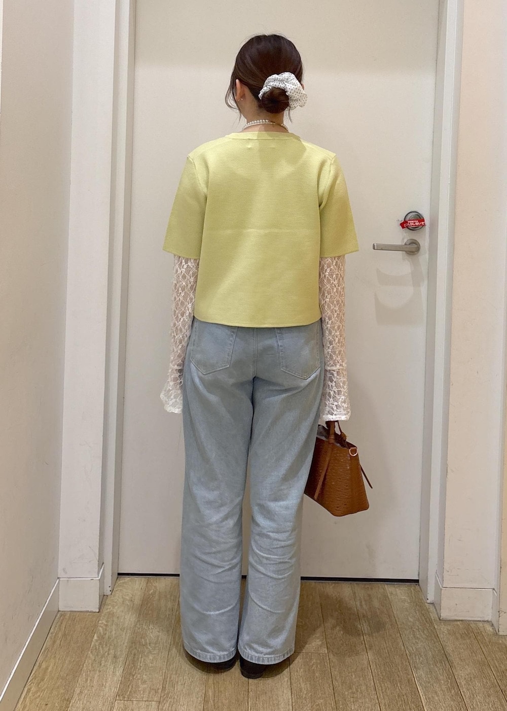 ブルー系のデニムパンツ、ブラウン系のショルダーバッグ、グリーン系のカーディガン/ボレロを着用したレディースの春コーディネートの3枚目の写真