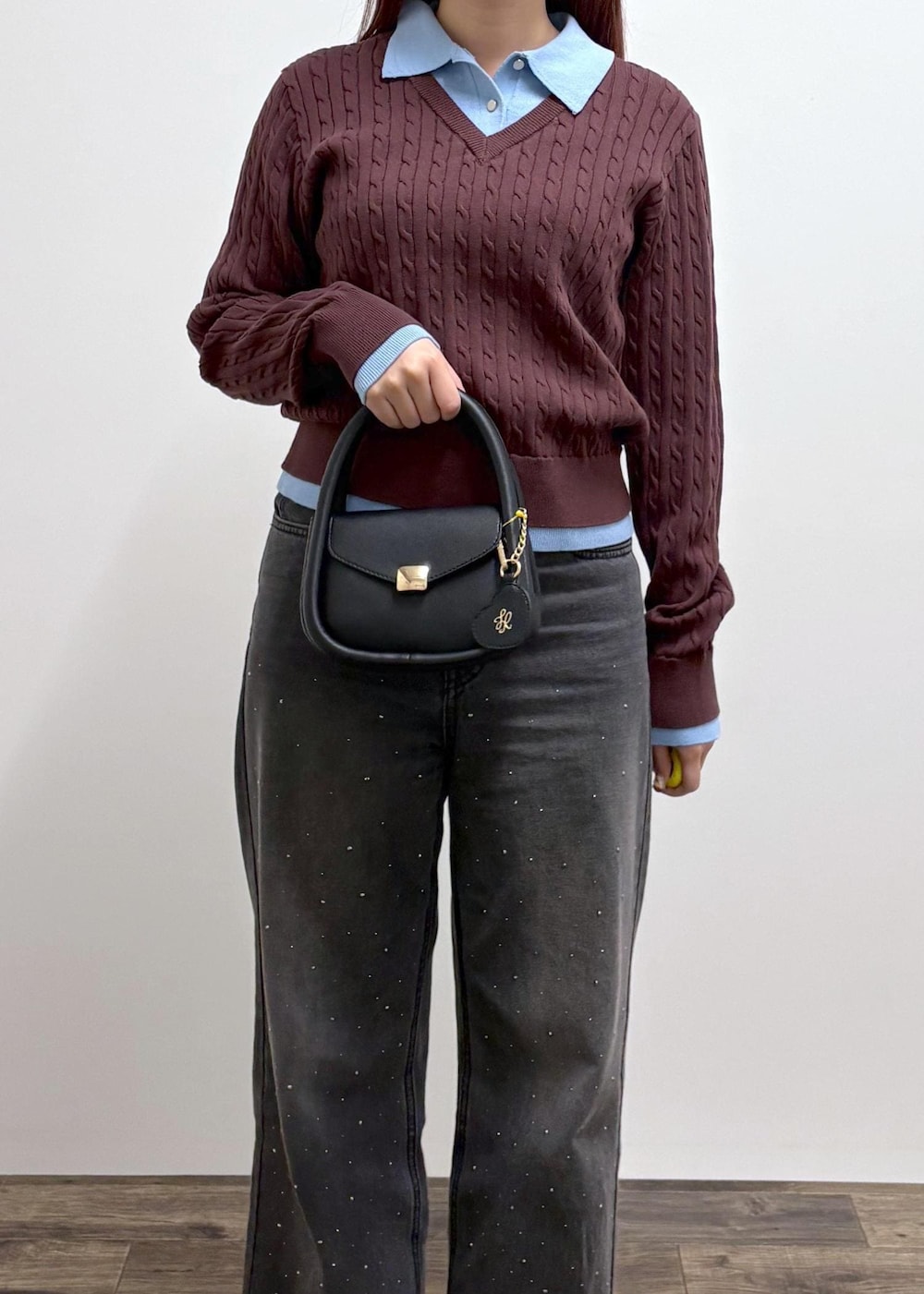 ブラック系のデニムパンツ、ブラック系のショルダーバッグ、ブラウン系のニット/セーターを着用したレディースの冬コーディネートの8枚目の写真