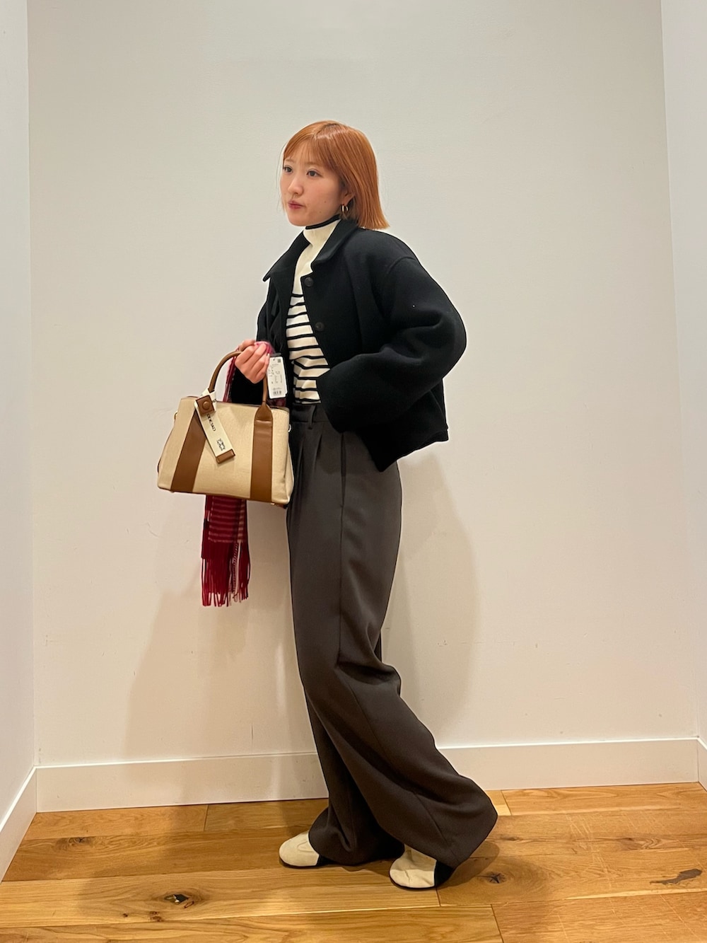 ブラウン系のニット/セーター、ベージュ系のハンドバッグ、ブラウン系のその他パンツを着用したレディースの冬コーディネートの2枚目の写真