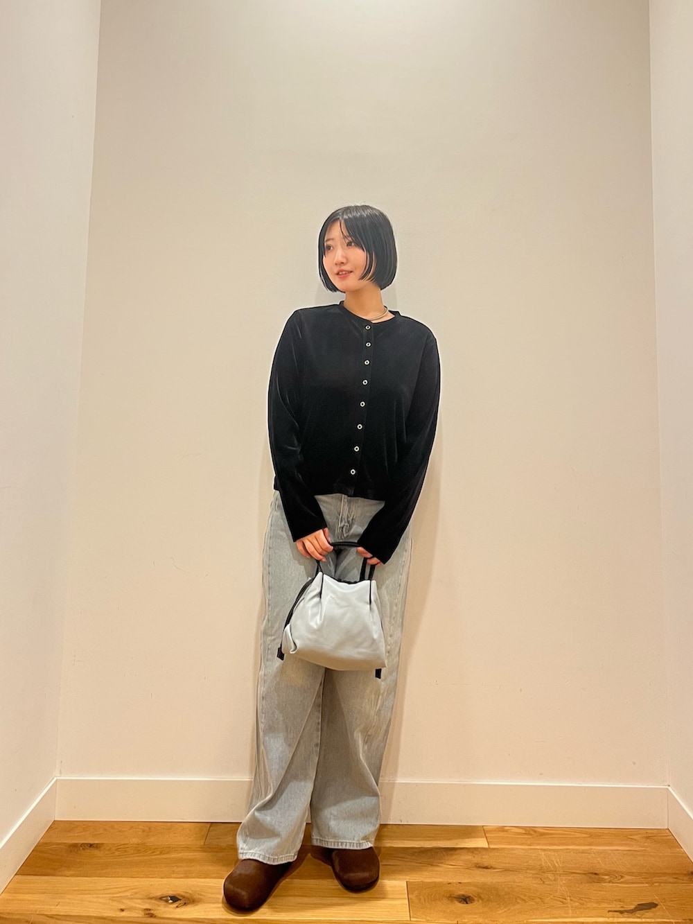 ブラック系のカーディガン/ボレロ、ブルー系のデニムパンツを着用したレディースの秋コーディネートの2枚目の写真