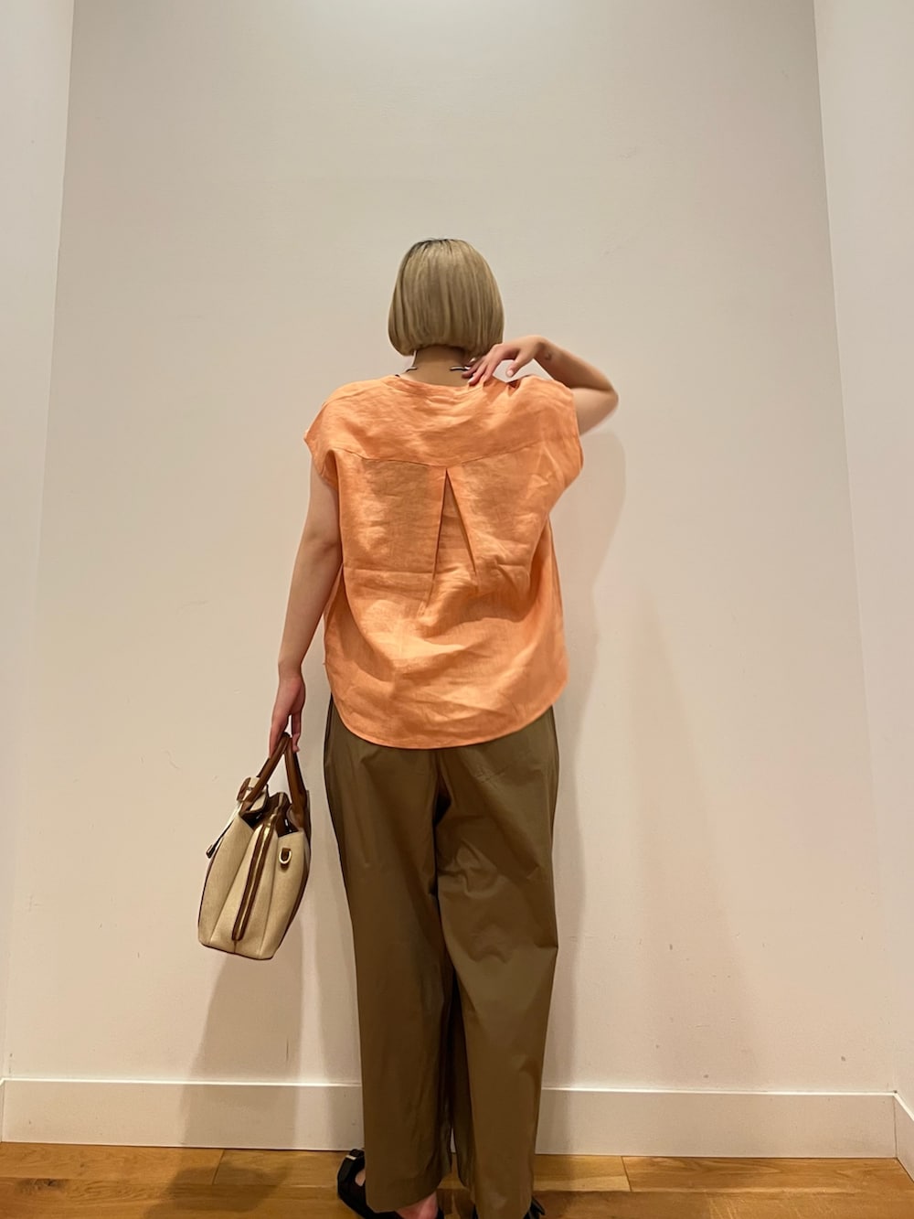 ベージュ系のその他パンツ、オレンジ系のシャツ/ブラウス、ブラック系のサンダルを着用したレディースの夏コーディネートの3枚目の写真
