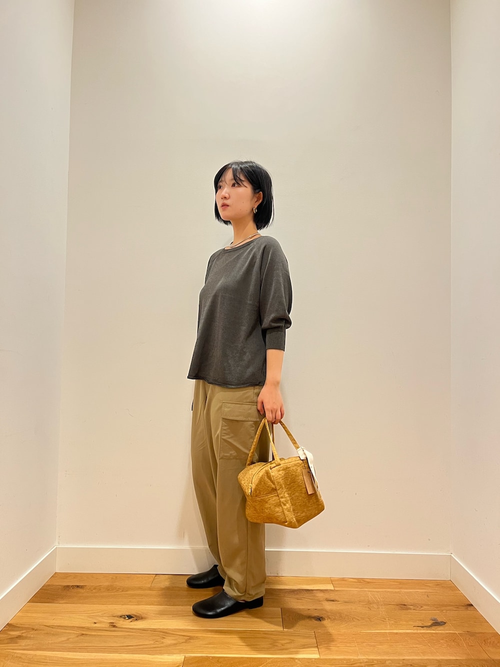 ベージュ系のその他パンツ、グレー系のニット/セーター、イエロー系のハンドバッグを着用したレディースの秋コーディネートの2枚目の写真