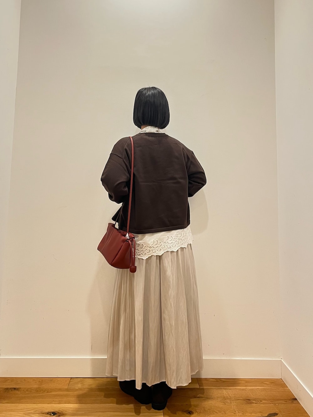ホワイト系のシャツ/ブラウス、ブラウン系のカーディガン/ボレロ、ホワイト系のスカートを着用したレディースの秋コーディネートの3枚目の写真