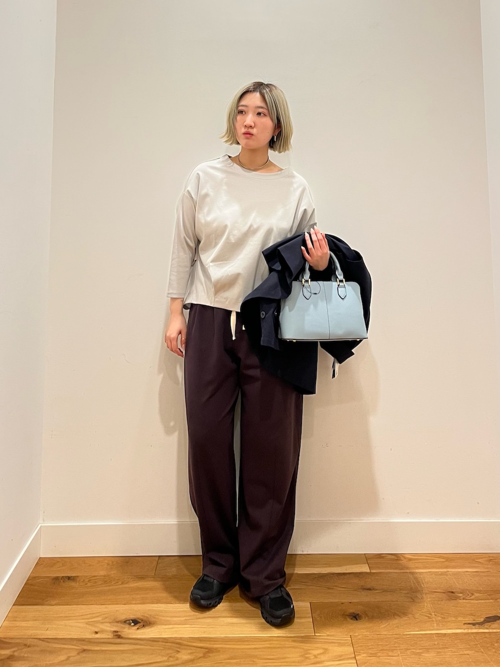 ブルー系のトレンチコート、ブルー系のTシャツ/カットソー、ブラウン系のその他パンツを着用したレディースの春コーディネートの2枚目の写真