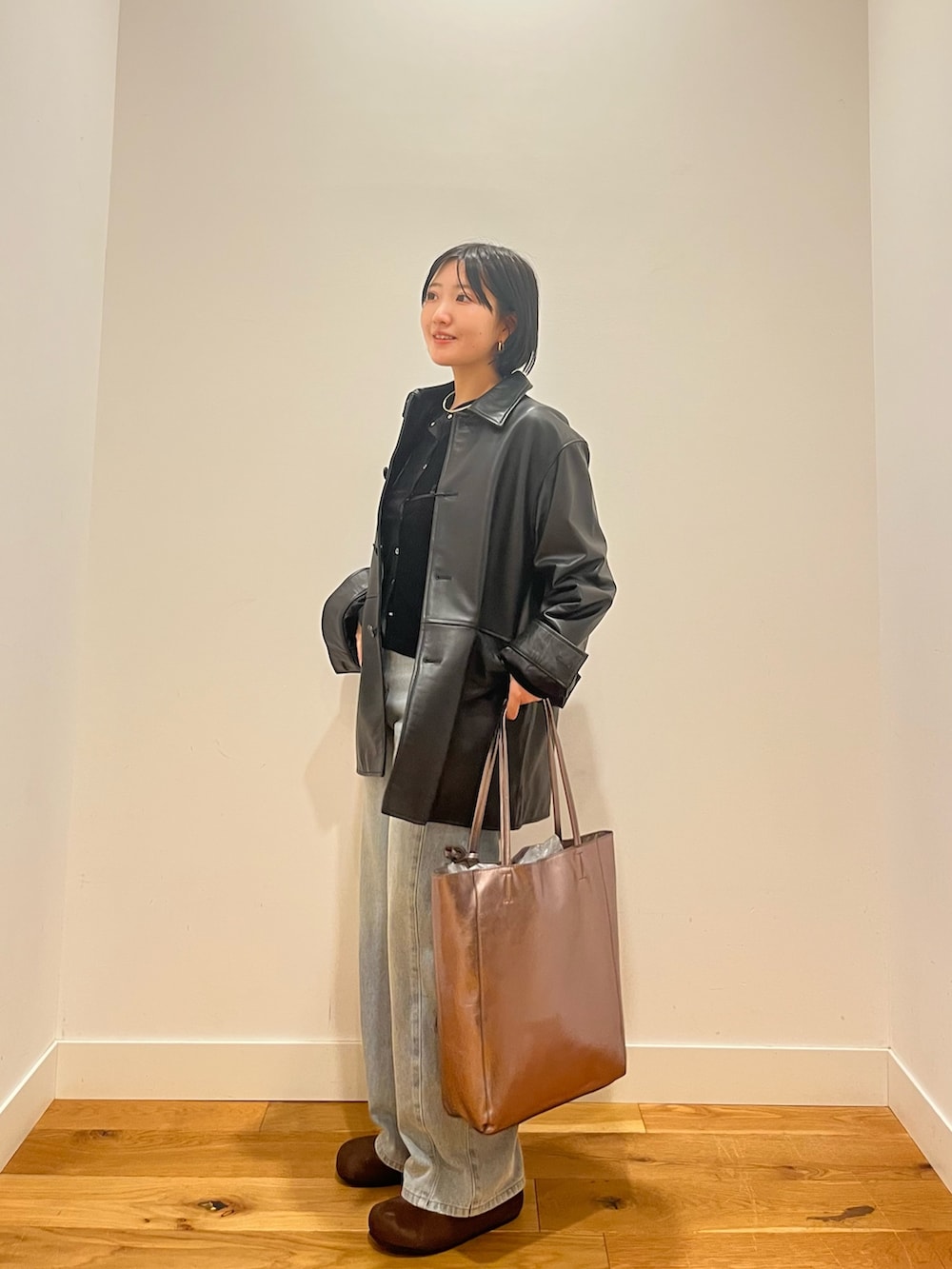 ブラック系のカーディガン/ボレロ、ブラック系のその他アウター、ブルー系のデニムパンツを着用したレディースの秋コーディネートの3枚目の写真