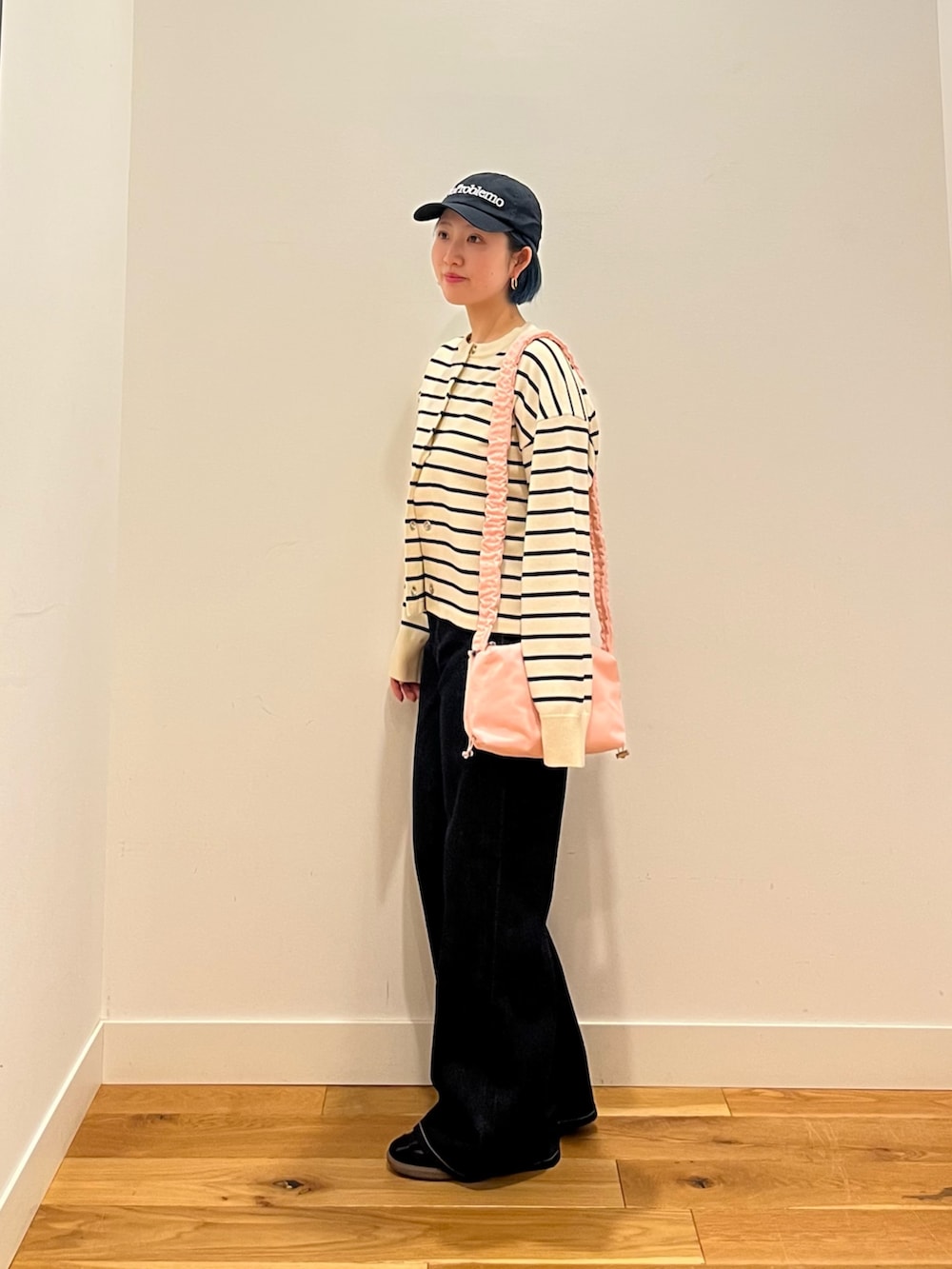 ホワイト系のカーディガン/ボレロ、ブルー系のデニムパンツを着用したレディースの春コーディネートの2枚目の写真