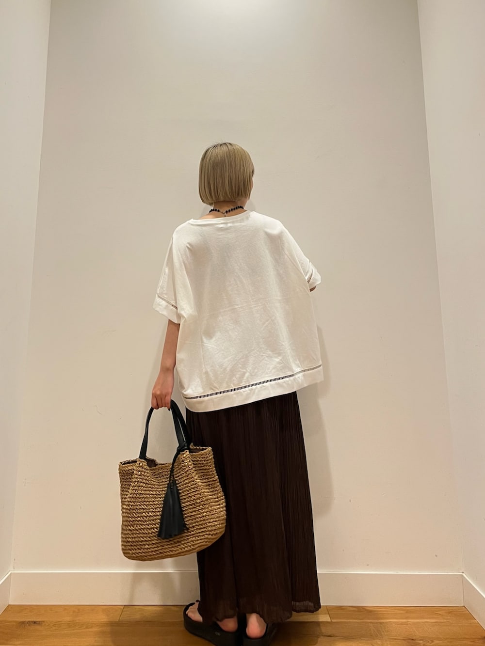 ブラウン系のスカート、ホワイト系のTシャツ/カットソー、ブルー系のネックレスを着用したレディースの夏コーディネートの3枚目の写真