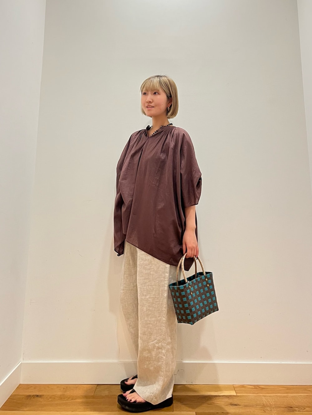 ブラウン系のシャツ/ブラウス、ベージュ系のその他パンツ、ブルー系のネックレスを着用したレディースの夏コーディネートの3枚目の写真