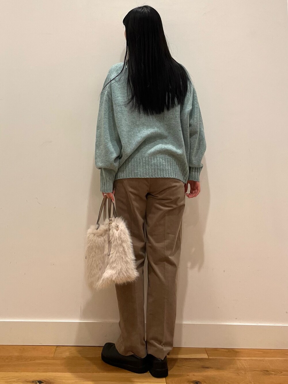 グリーン系のニット/セーター、ベージュ系のその他パンツ、シルバー系のネックレスを着用したレディースの秋コーディネートの3枚目の写真