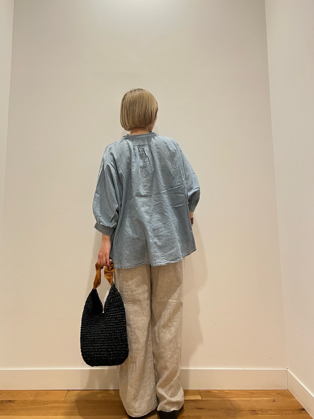 ベージュ系のその他パンツ、ブルー系のシャツ/ブラウス、オレンジ系のかごバッグを着用したレディースの夏コーディネートの4枚目の写真