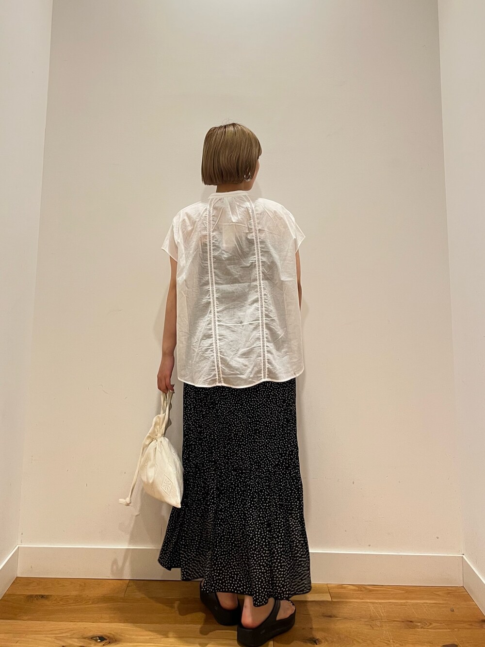 ホワイト系のシャツ/ブラウス、ブラック系のスカート、ホワイト系のショルダーバッグを着用したレディースの夏コーディネートの3枚目の写真