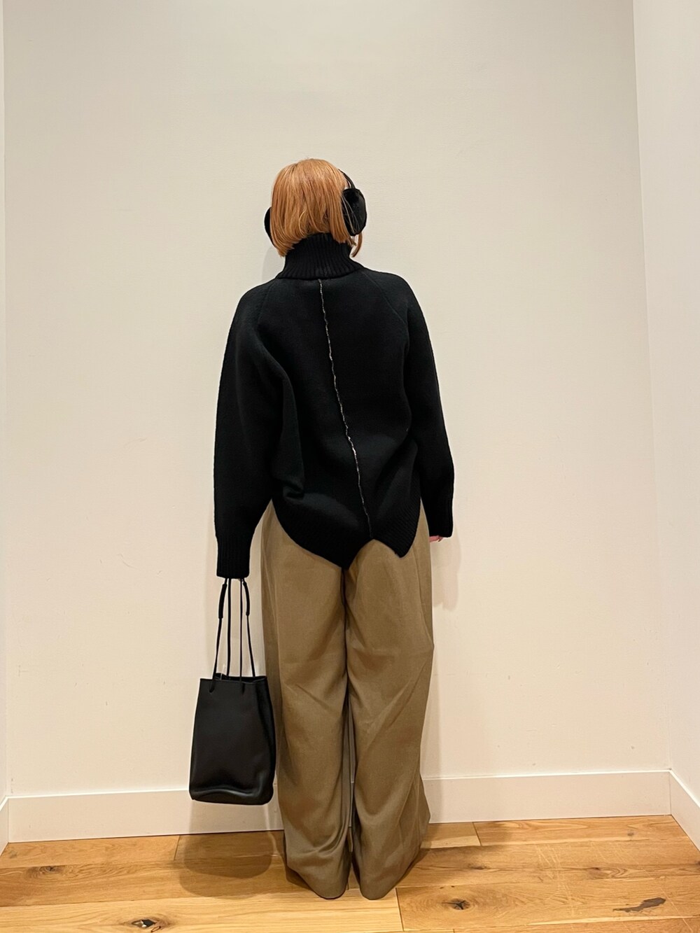 ブラック系のショルダーバッグ、イエロー系のその他パンツ、ブラック系のニット/セーターを着用したレディースの冬コーディネートの3枚目の写真