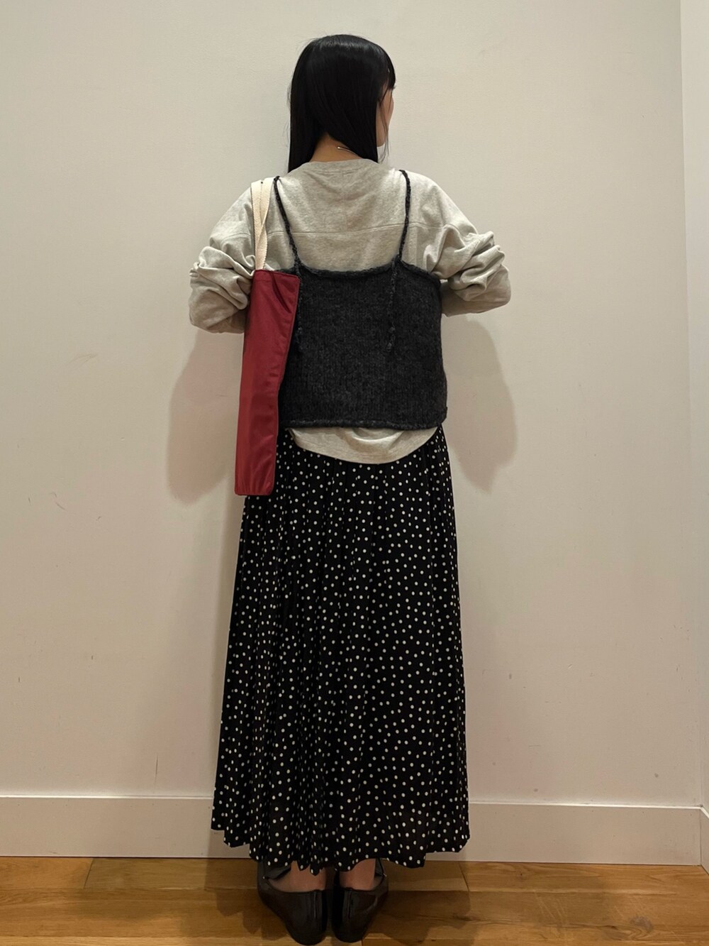 グレー系のTシャツ/カットソー、ブラック系のニット/セーター、ブラック系のスカートを着用したレディースの秋コーディネートの3枚目の写真