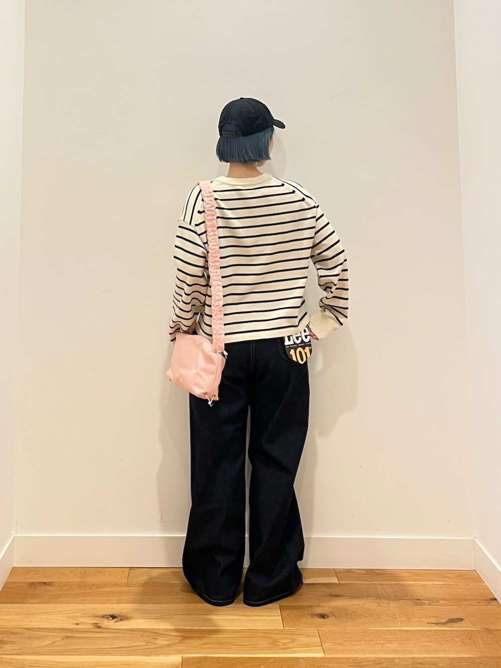 ホワイト系のカーディガン/ボレロ、ブルー系のデニムパンツを着用したレディースの春コーディネートの3枚目の写真