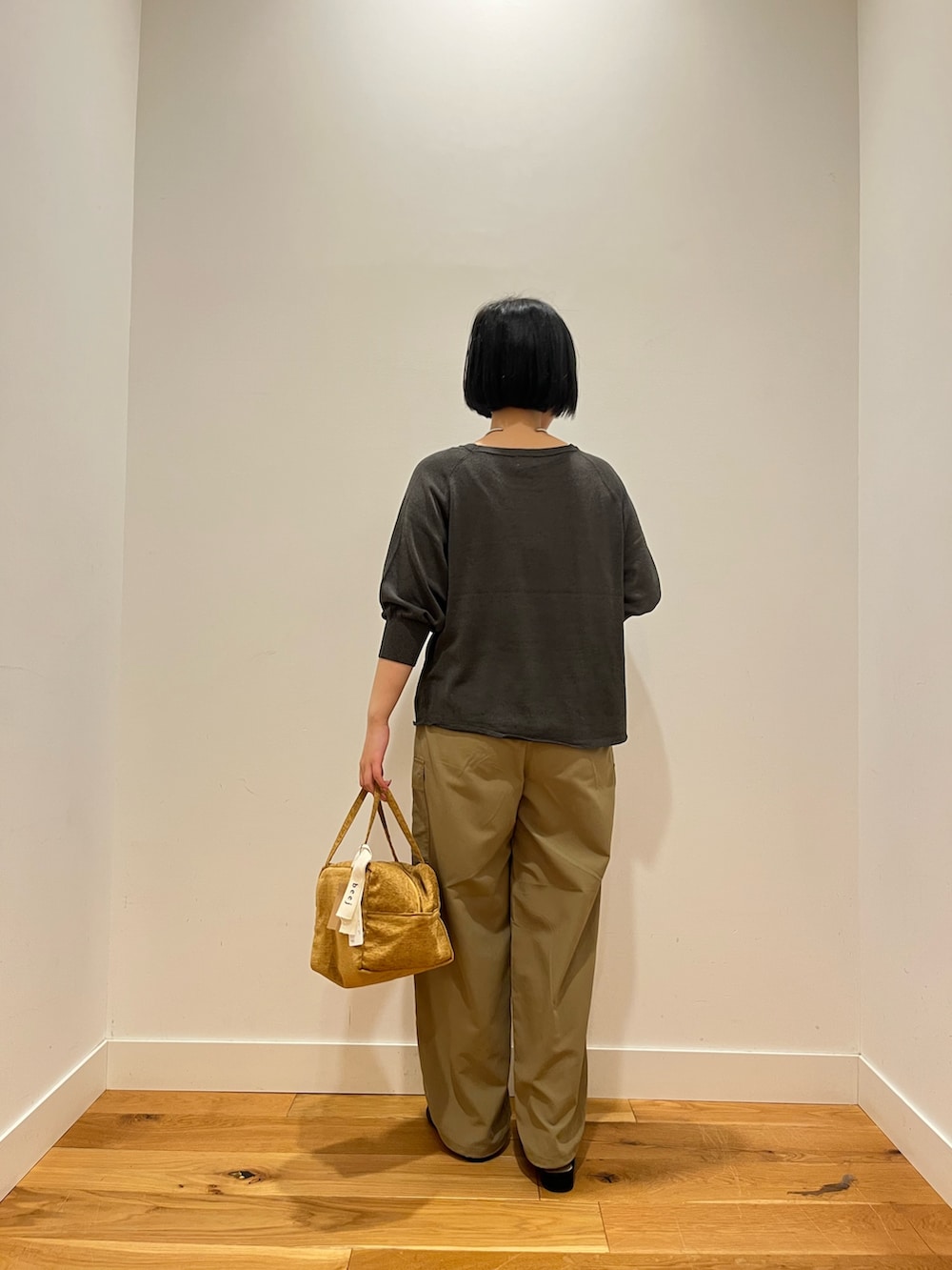 ベージュ系のその他パンツ、グレー系のニット/セーター、イエロー系のハンドバッグを着用したレディースの秋コーディネートの3枚目の写真
