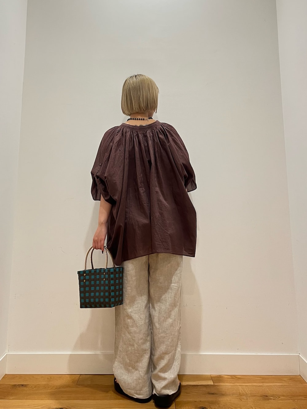 ブラウン系のシャツ/ブラウス、ベージュ系のその他パンツ、ブルー系のネックレスを着用したレディースの夏コーディネートの4枚目の写真