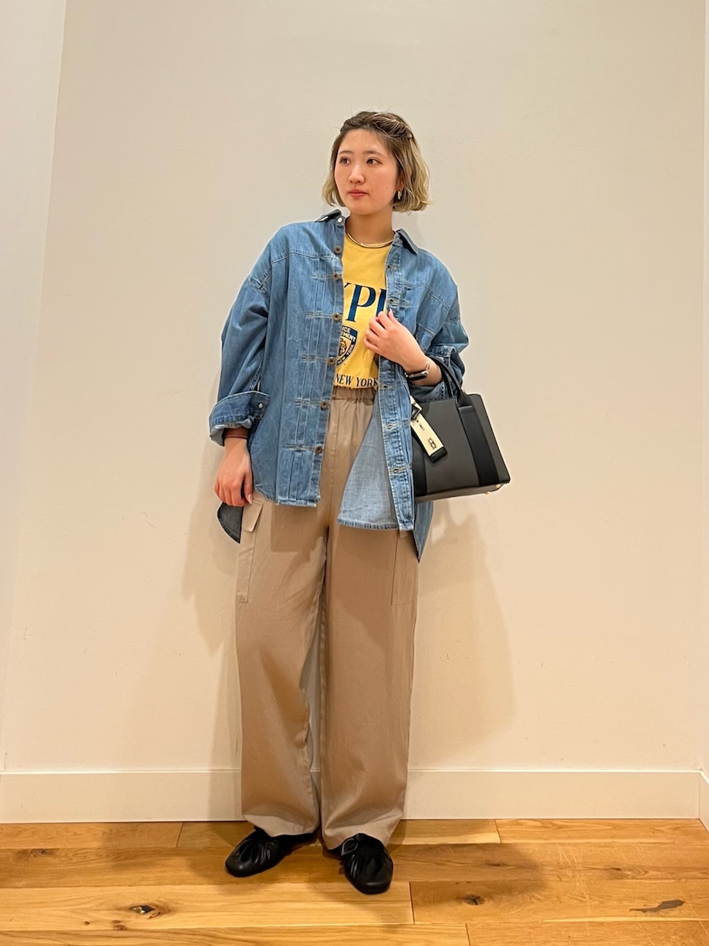 イエロー系のTシャツ/カットソー、ブルー系のシャツ/ブラウス、ベージュ系のその他パンツを着用したレディースの春コーディネートの2枚目の写真