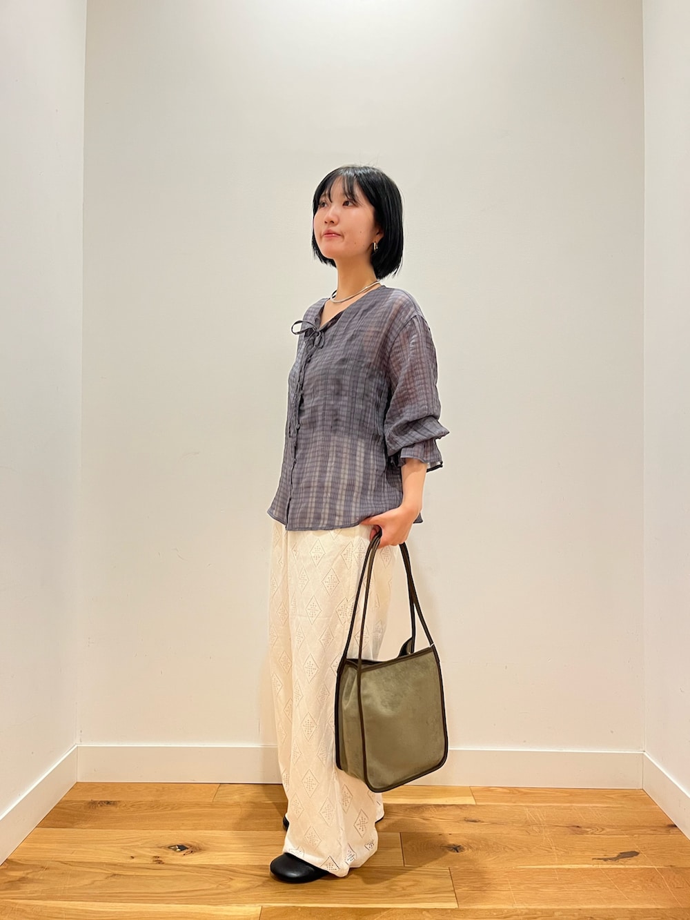 ブルー系のシャツ/ブラウス、ホワイト系のその他パンツ、グリーン系のトートバッグを着用したレディースの秋コーディネートの2枚目の写真