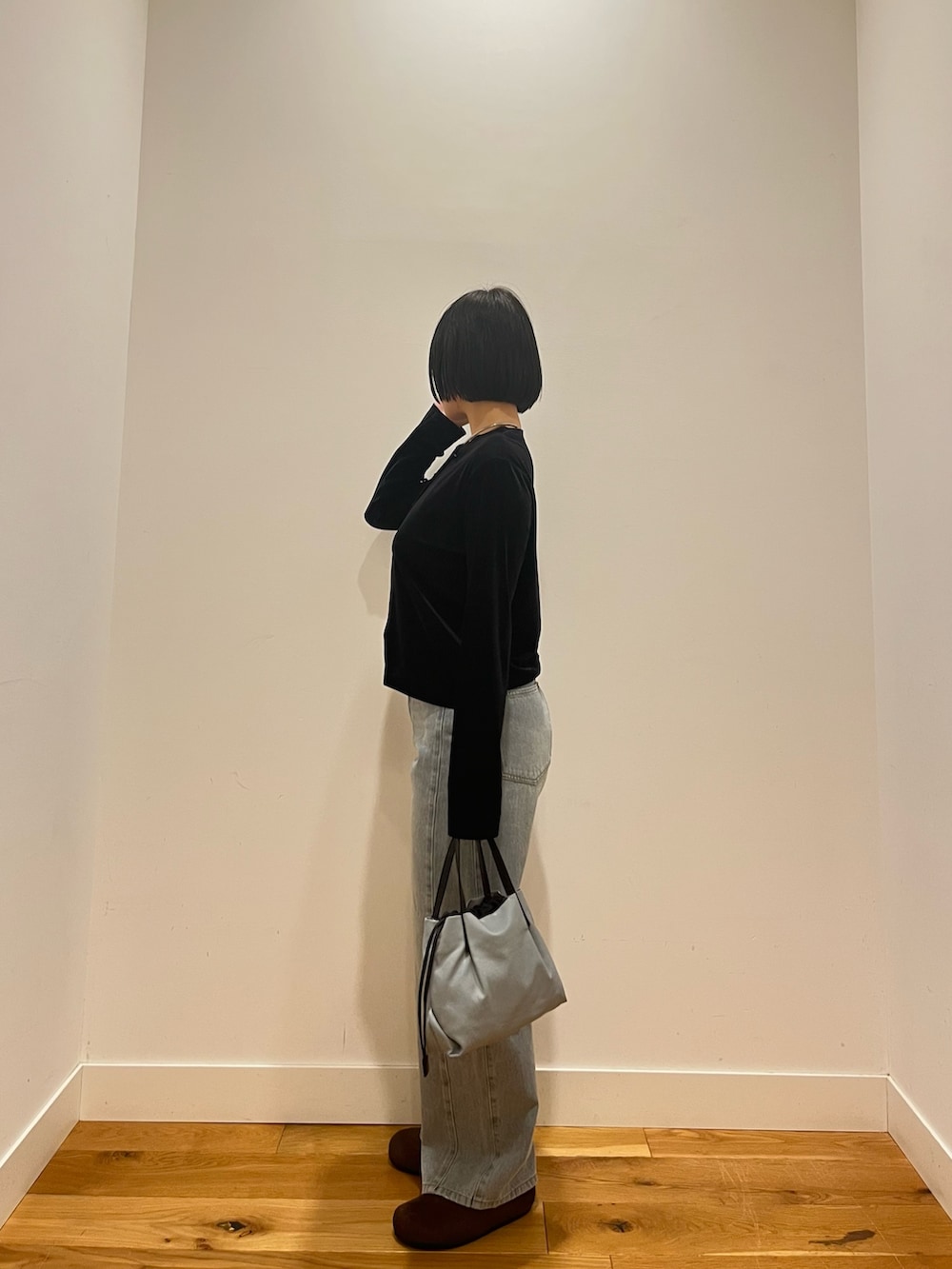 ブラック系のカーディガン/ボレロ、ブルー系のデニムパンツを着用したレディースの秋コーディネートの3枚目の写真