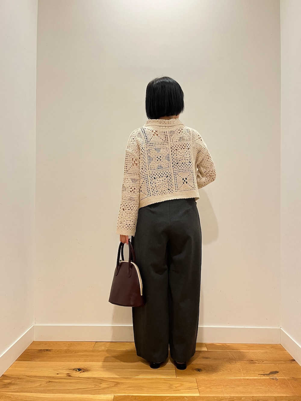 ベージュ系のカーディガン/ボレロ、グレー系のその他パンツ、レッド系のハンドバッグを着用したレディースの秋コーディネートの3枚目の写真