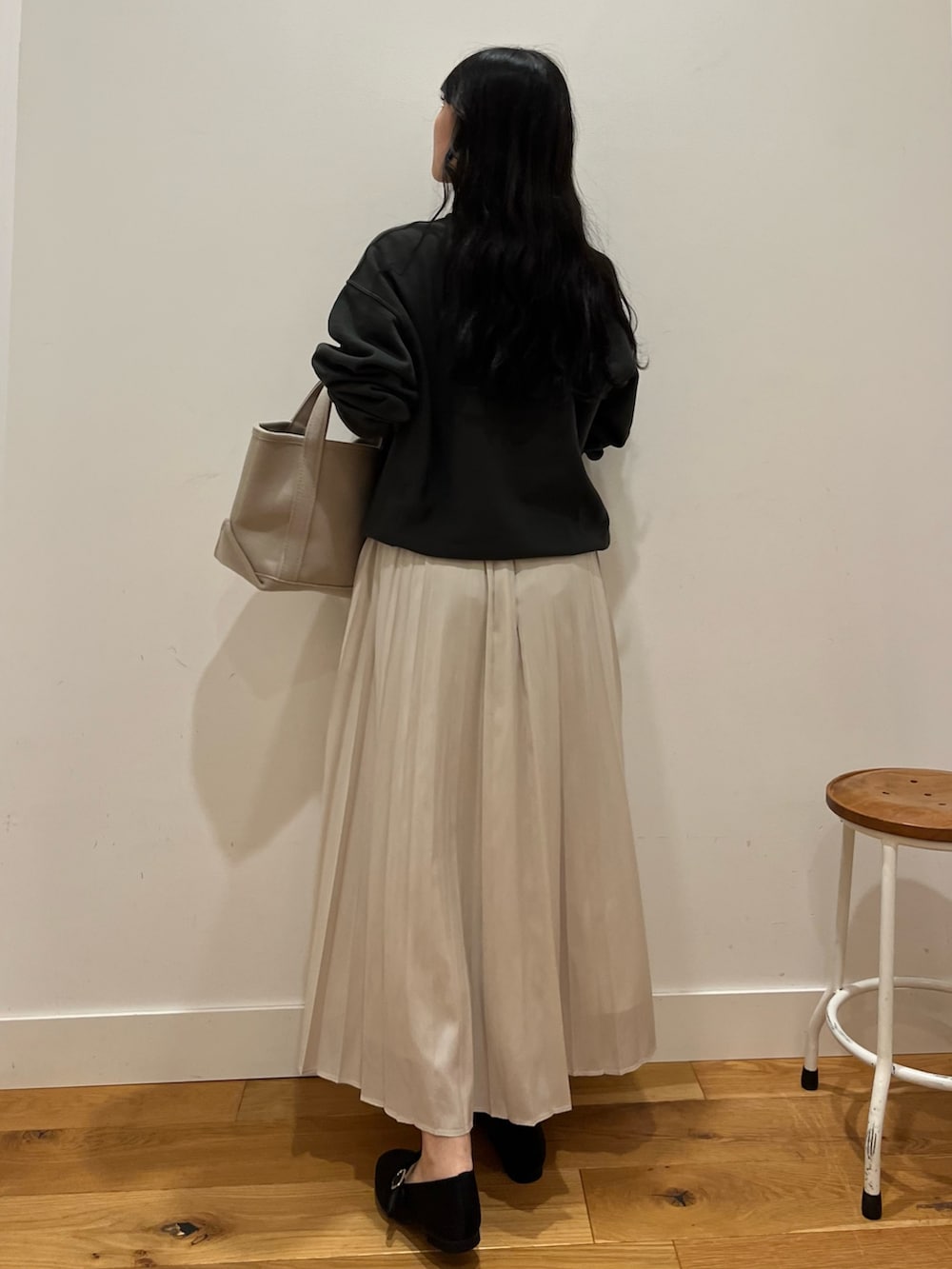 ブラック系のスウェット、ブラウン系のスカート、ベージュ系のトートバッグを着用したレディースの秋コーディネートの3枚目の写真