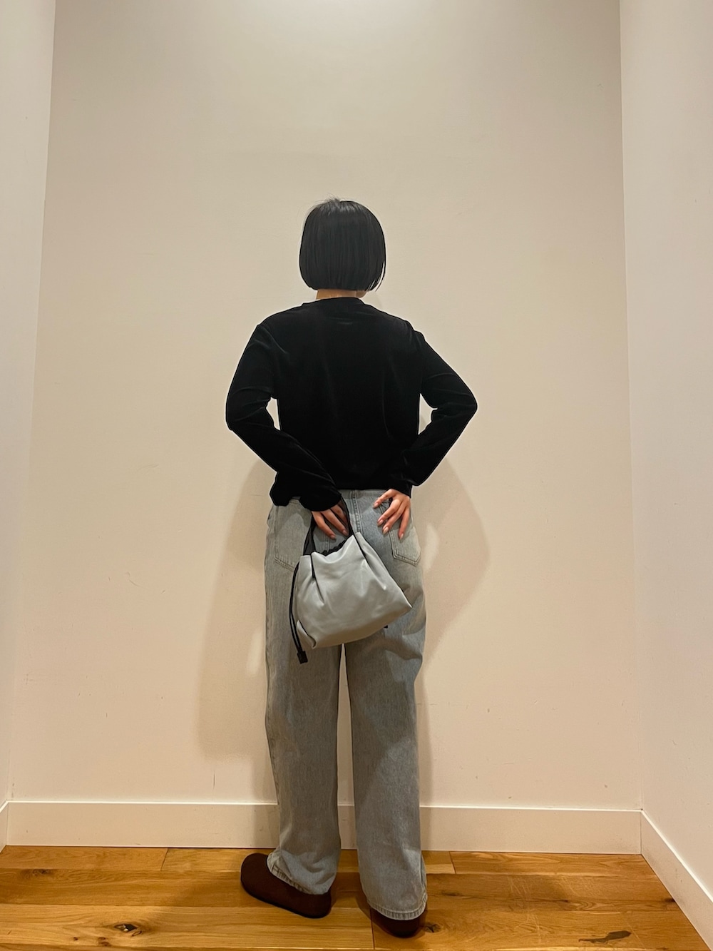 ブラック系のカーディガン/ボレロ、ブルー系のデニムパンツを着用したレディースの秋コーディネートの4枚目の写真