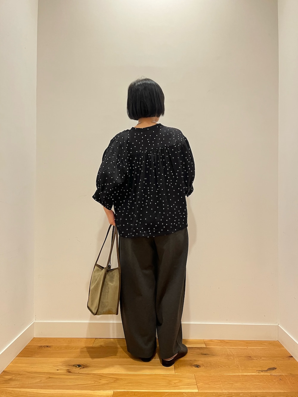 グレー系のその他パンツ、ブラック系のシャツ/ブラウス、グリーン系のトートバッグを着用したレディースの秋コーディネートの3枚目の写真