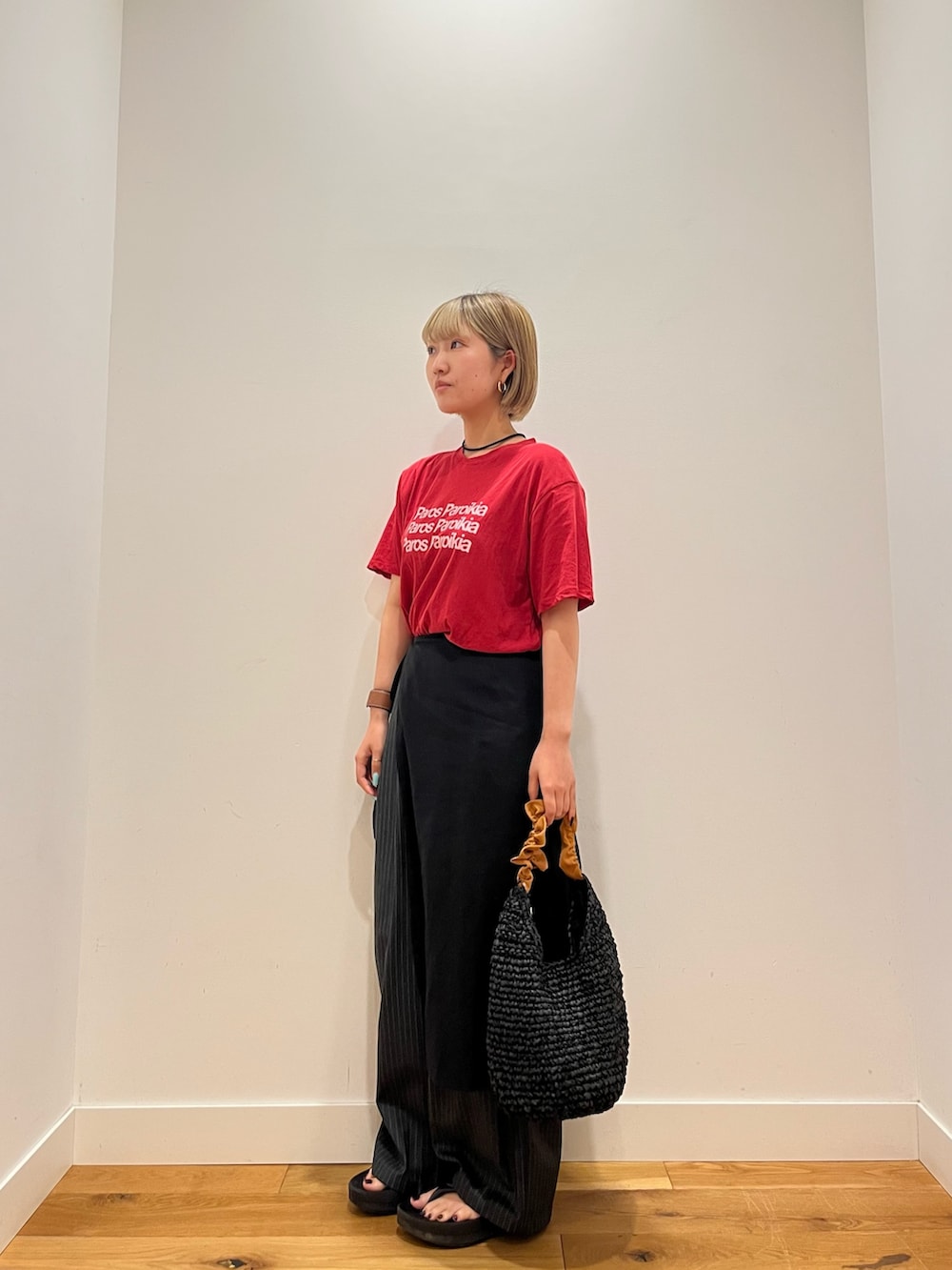 レッド系のTシャツ/カットソー、オレンジ系のかごバッグを着用したレディースの夏コーディネートの3枚目の写真