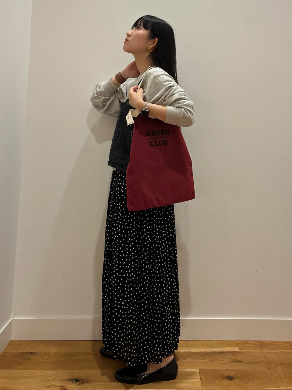 グレー系のTシャツ/カットソー、ブラック系のニット/セーター、ブラック系のスカートを着用したレディースの秋コーディネートの2枚目の写真