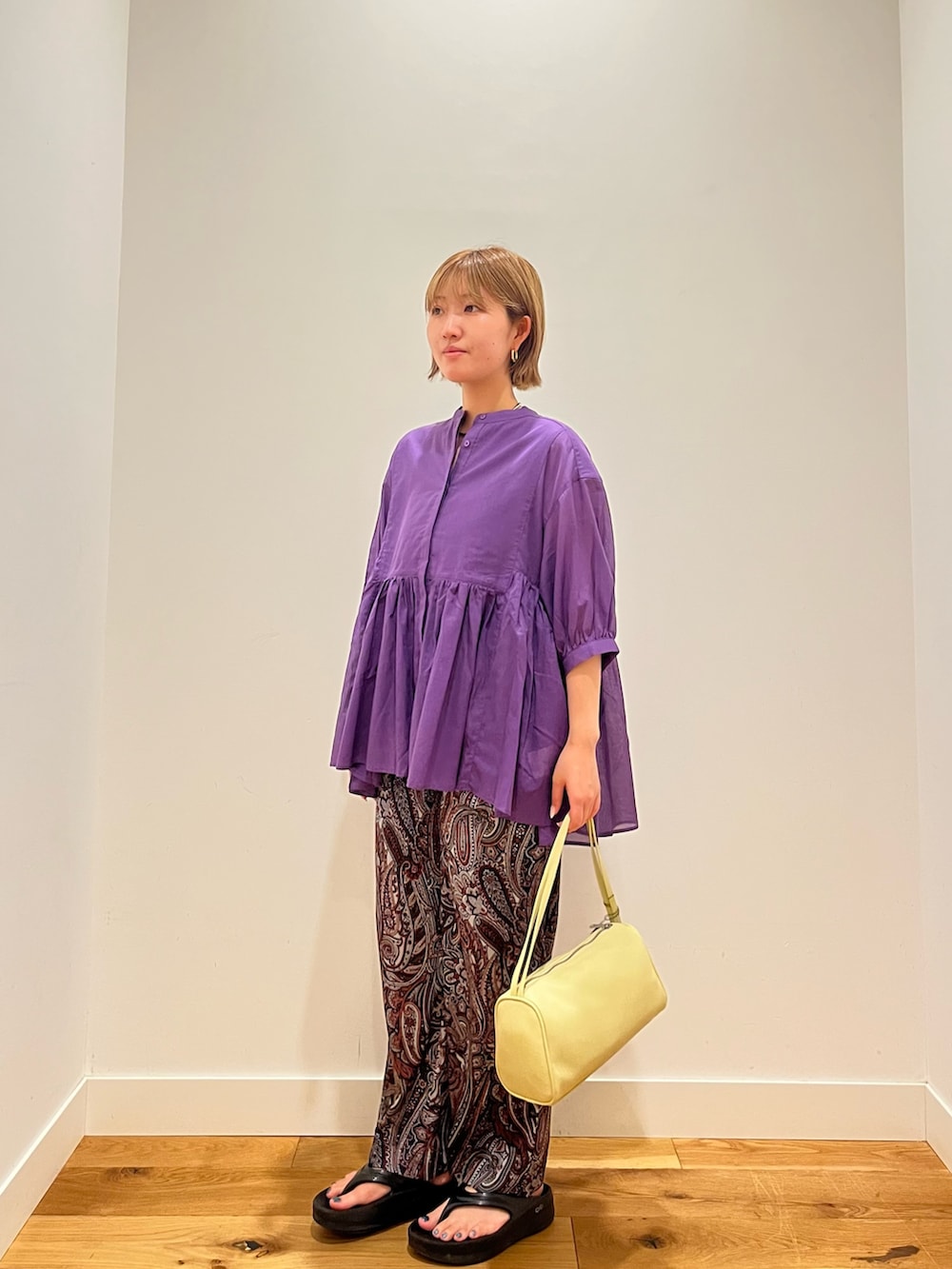 パープル系のシャツ/ブラウス、レッド系のその他パンツ、イエロー系のハンドバッグを着用したレディースの夏コーディネートの2枚目の写真
