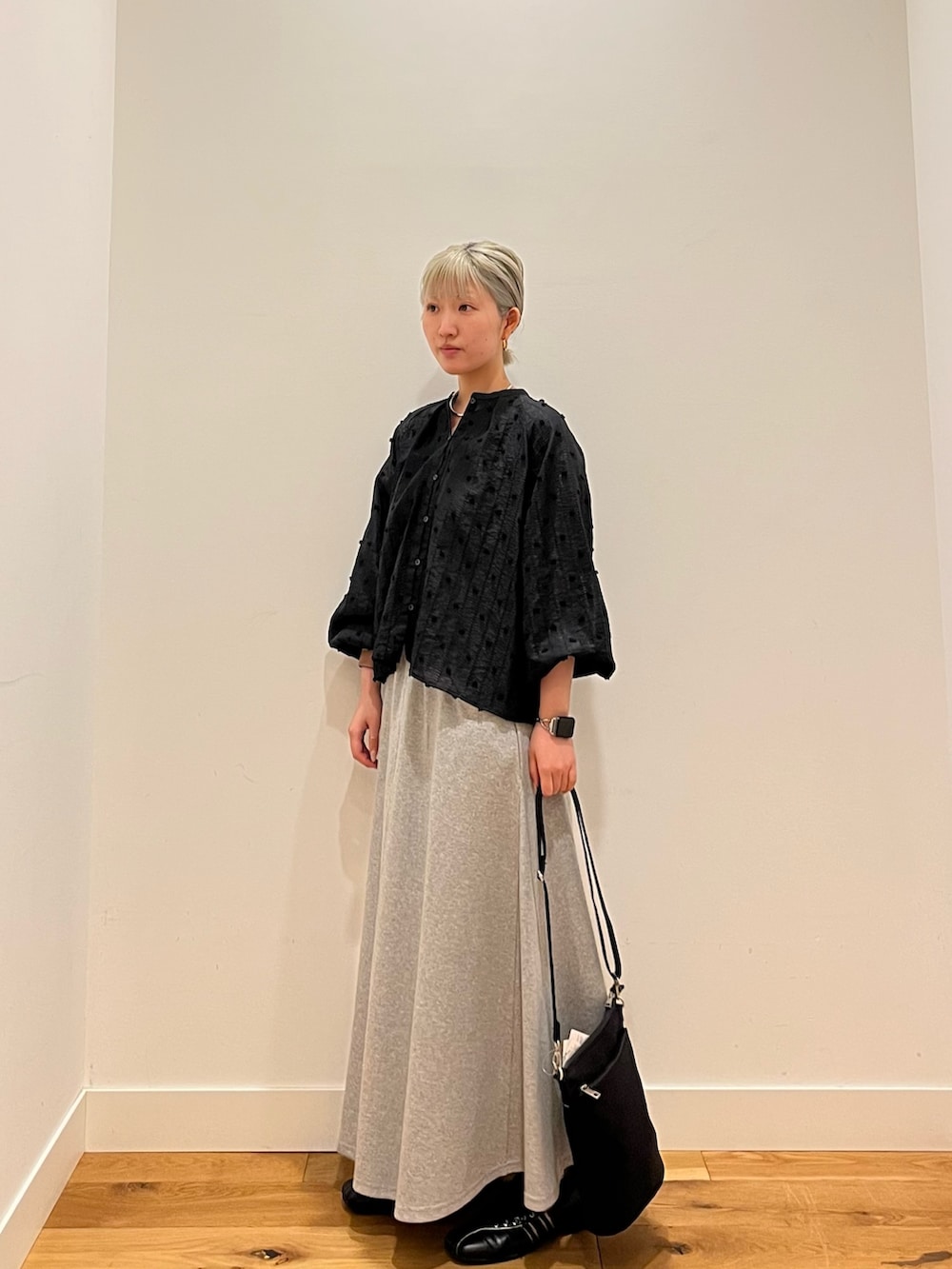 ブラック系のシャツ/ブラウス、グレー系のスカートを着用したレディースの春コーディネートの2枚目の写真