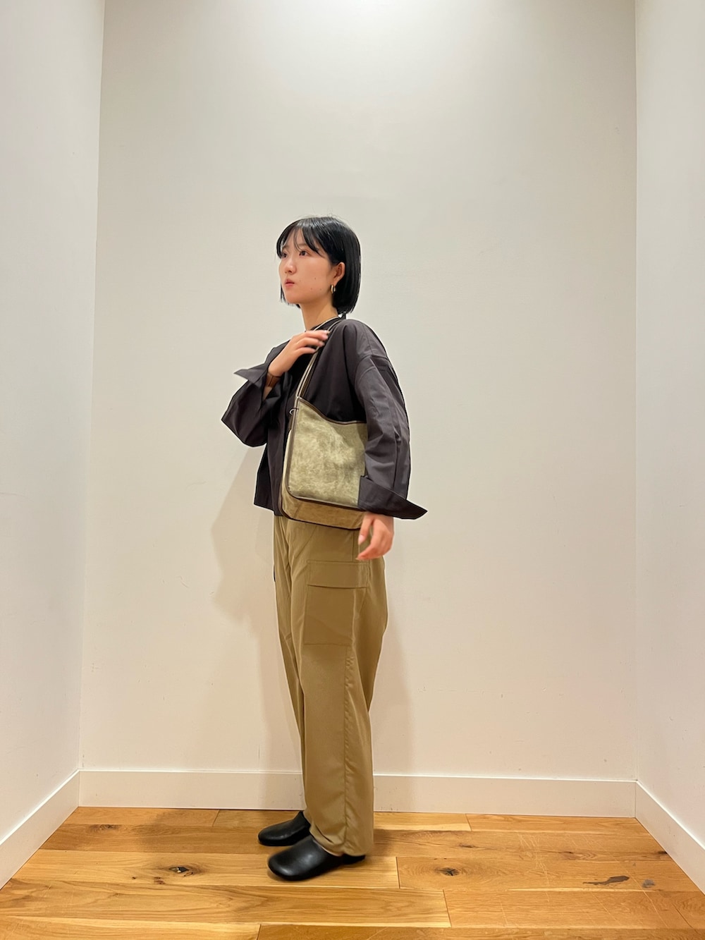 ベージュ系のその他パンツ、ブラウン系のシャツ/ブラウス、グリーン系のトートバッグを着用したレディースの夏コーディネートの2枚目の写真
