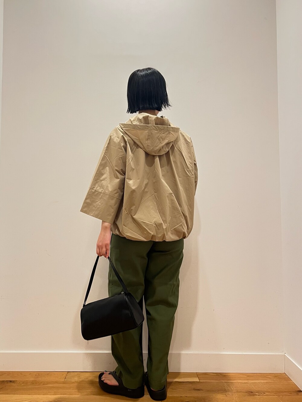 ベージュ系のその他アウター、グリーン系のその他パンツ、ブラック系のハンドバッグを着用したレディースの秋コーディネートの3枚目の写真