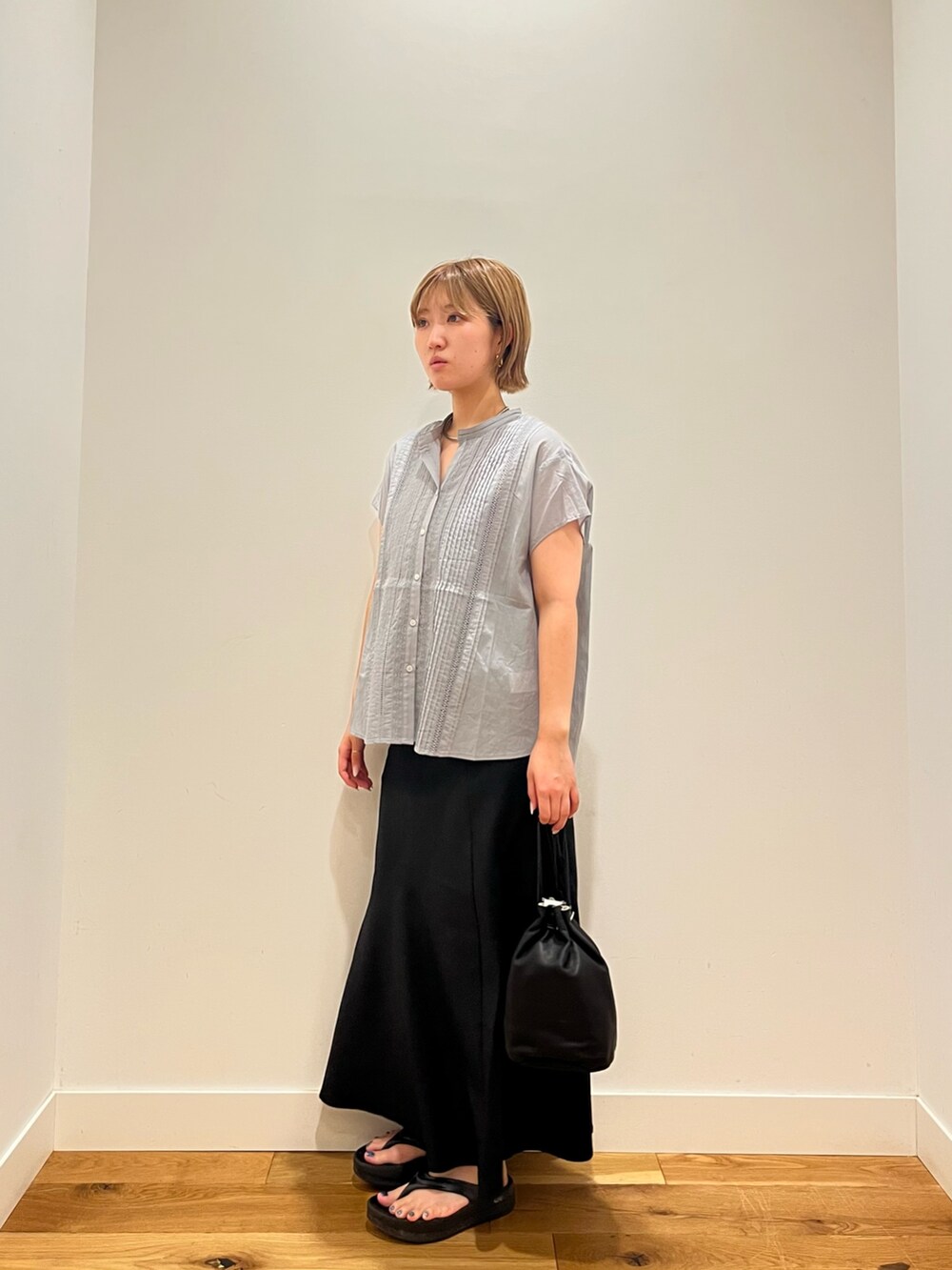 グレー系のシャツ/ブラウス、ブラック系のスカート、ブラック系のショルダーバッグを着用したレディースの夏コーディネートの2枚目の写真