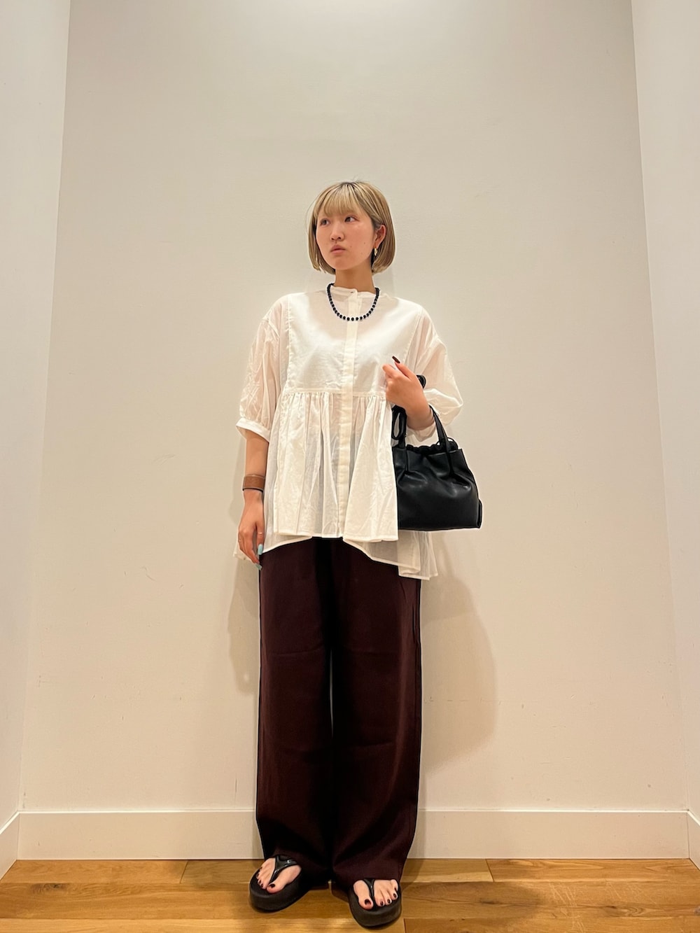 レッド系のその他パンツ、グレー系のシャツ/ブラウス、ブルー系のネックレスを着用したレディースの夏コーディネートの2枚目の写真
