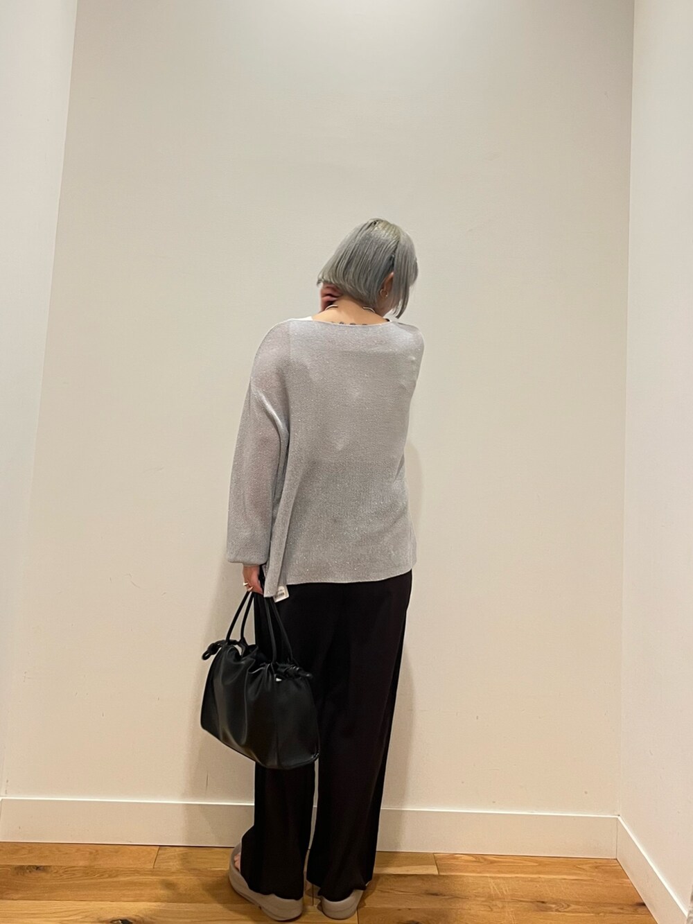 ブルー系のニット/セーター、グレー系のその他パンツを着用したレディースの春コーディネートの3枚目の写真