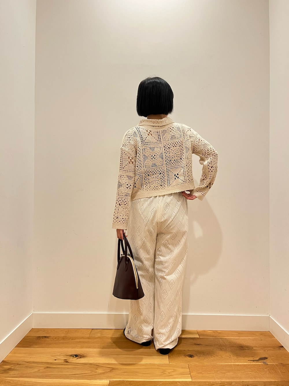 ベージュ系のカーディガン/ボレロ、ホワイト系のその他パンツ、レッド系のハンドバッグを着用したレディースの秋コーディネートの3枚目の写真